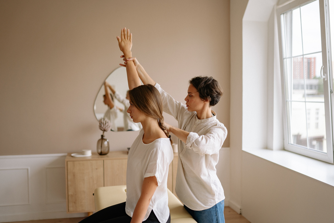 A Woman Stretching Another Woman's Arm